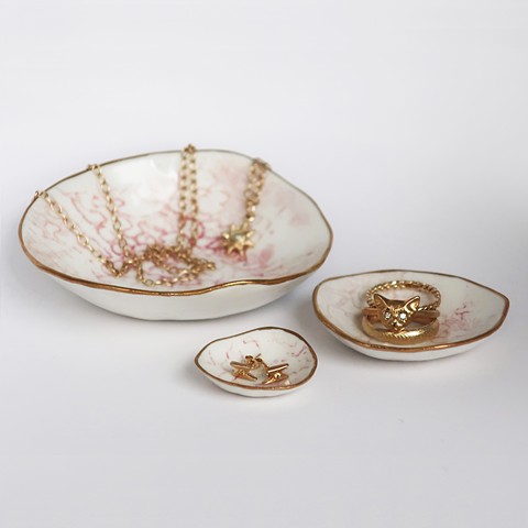 Pink & white lace nesting dishes with assorted gold jewelry