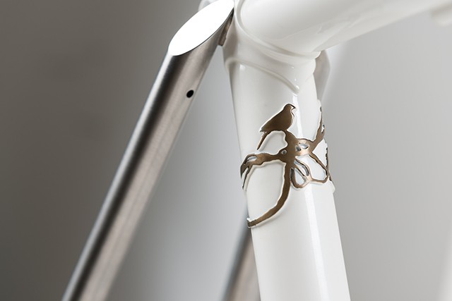 Brass detail of a bird on a vine that wraps around the seat tube, and another look at the polished side tack facet on the brushed seat stays