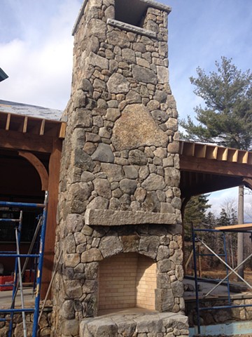 Outside fireplace finished with stone gathered from property.