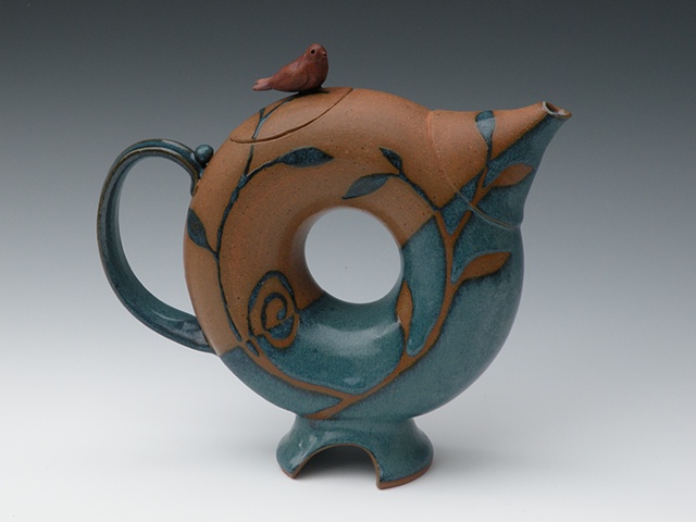 Donut shape teapot with turqoise glaze and bird on lid