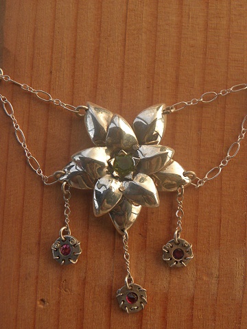 delicate sterling silver flower necklace featuring peridot, ruby, and garnet facets