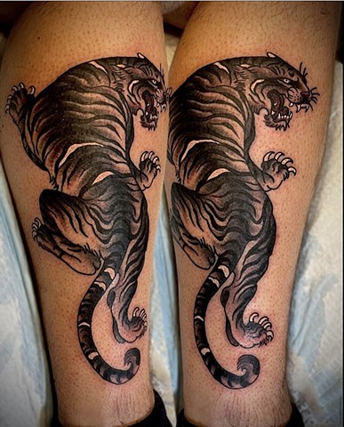 A Western Traditional style, black and grey tiger crawling up on the forearm