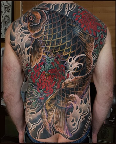A Japanese themed back tattoo covering a few large, old tattoos, featuring a giant black koifish and red chrysanthemum flowers