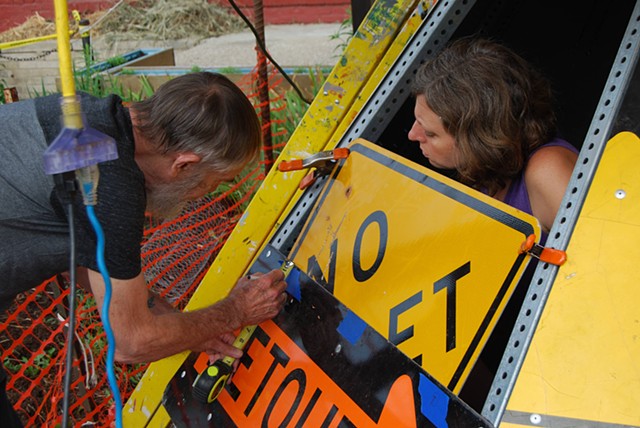 Volunteers attaching street signs to the roof structure
