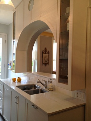 An archway cut into the kitchen wall opens up the dining room by Jane Interiors NYC, kitchen with bar counter, kitchen with open wall, small kitchen design