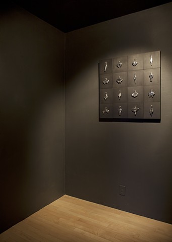wall installation comprised of cast aluminum, wood, graphite, and sewing needles by Mary Meyer