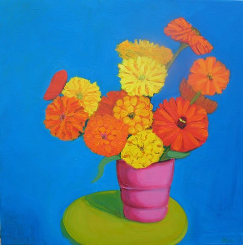 colorful zinnias on blue background and a green stool