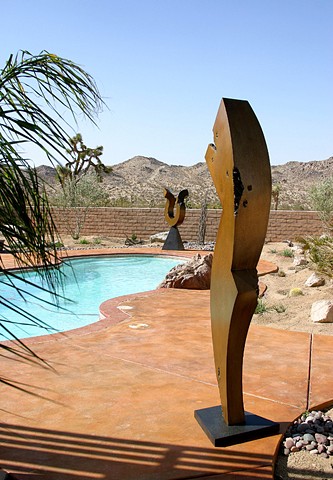 Large outdoor figurative bronze sculpture with golden patina.