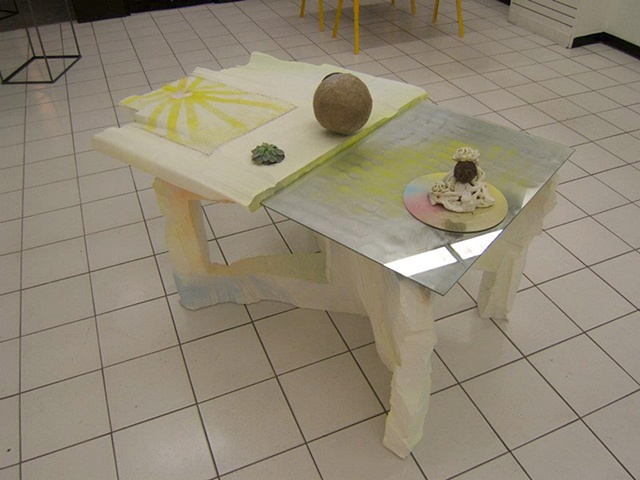 sculptural painting and table with mirrors and plant