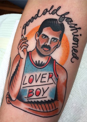 Traditional arm tattoo of Freddy Mercury in bold colour, portrait, made in Toronto