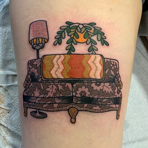 Couch or sofa furniture tattoo in a simple traditional tattoo style with 1970s touches made in subtle colours by Jenny Boulger in Halifax Nova Scotia