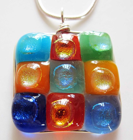 "Modern art for your neck..."

details:
fused glass and silver wire wrapped
1" square pendant
comes on 18" classic silver snake chain