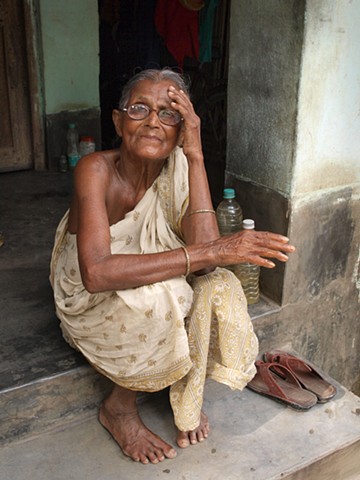 Elderly village woman on step