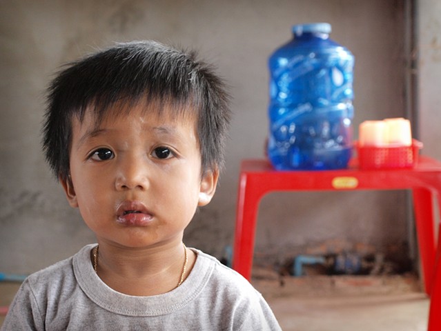 Toddler in his village home, which doubles as a shop