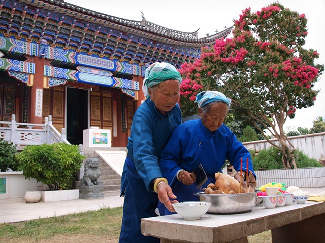 Two women preparing sacrifice to temple idols