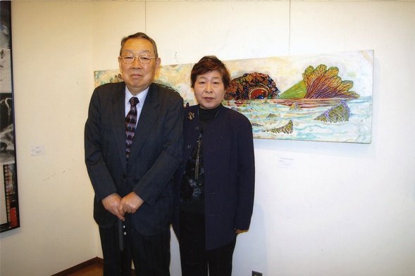 Dr. and Mrs. Saito with Kathleen King's paintings.