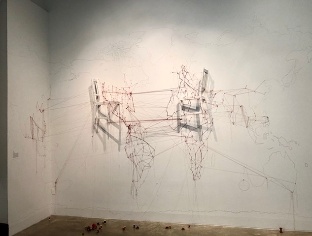 An installation reflecting on the overwhelming scale of displacement and migration in the present day. A hand-drawn map and researched routes most often traveled are indicated with extended red threads across territories, both watery and earthen.  Relocat