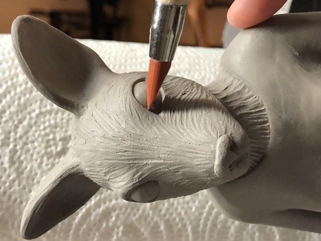 Detailing eye of clay animal lady.