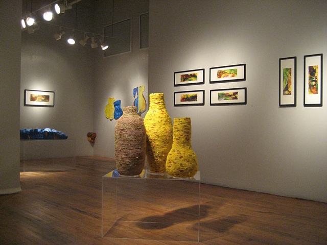 Closer view of three vessels in the space with paintings in the background.