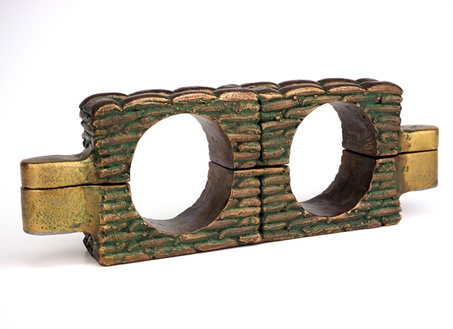 Fully functional cast bronze sandbag-stack shackle stocks with double lock mechanism.