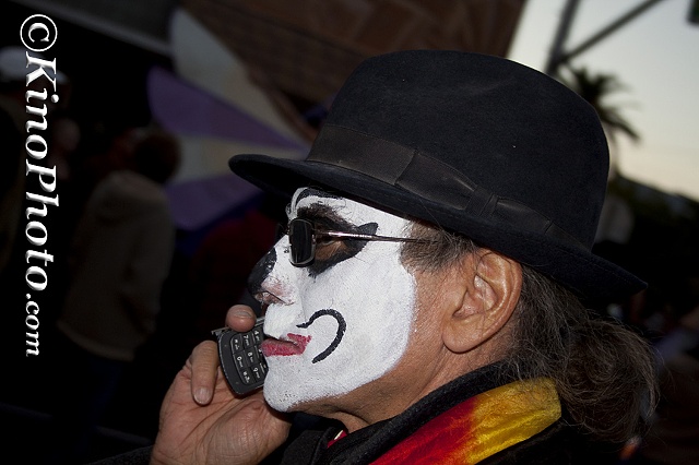 Man with a cell phone at All Souls Procession.  "Can you hear me now"
