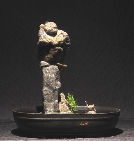 stone inuksuk tower with waterfall and leptinella plant