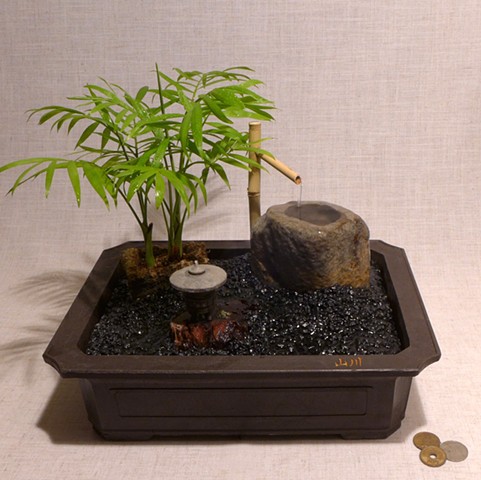 tabletop fountain garden with Neanthe Bella Palm, Malaysian driftwood, cast stone lantern, brass miniature