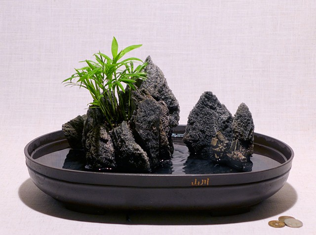 Asian featherock fountain with mudman miniatures and Neanthe Bella palm