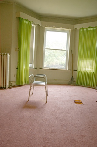 a desolate room that's occupant has moved out or died with a commode chair and ashtray remaining by lucy mueller