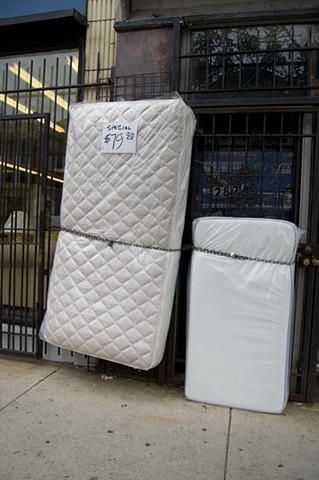 mattresses chained as if escaping in front of a city store photographed by Lucy Mueller Photography