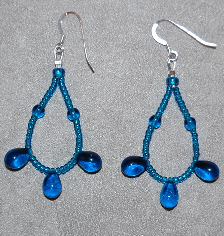 Earrings of delicate loop of Capri blue glass teardrops with capri blue glass seed beads looped on Sterling silver French ear wires.