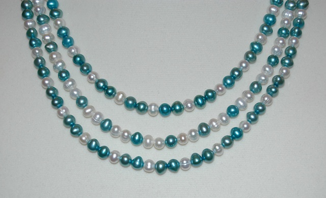 Triple strand Necklace of Freshwater Pearls alternating in white and jade green with Sterling silver clasp.