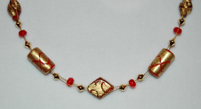 Triple strand interwoven necklace of 22K gold leaf over glass beads