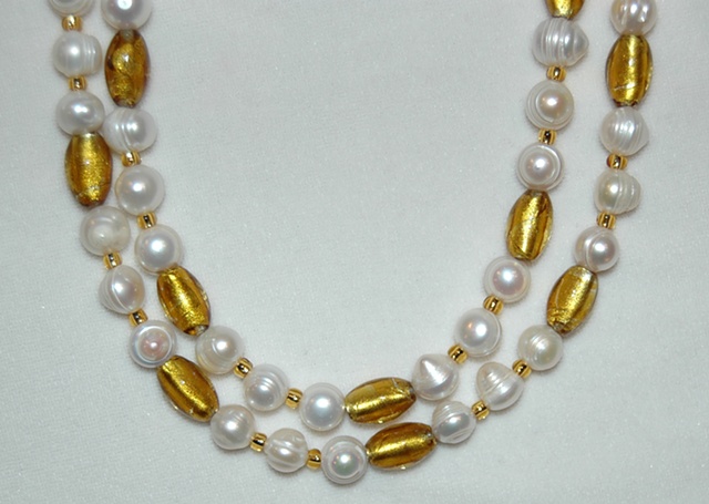 Necklace of large white Freshwater pearls and tapered tube-shaped amber colored Murano style glass beads accented with amber  glass seed beads 