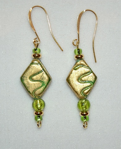 Earrings of incised gold foil over green glass bead, diamond-shaped, accented with green murano style glass bead
