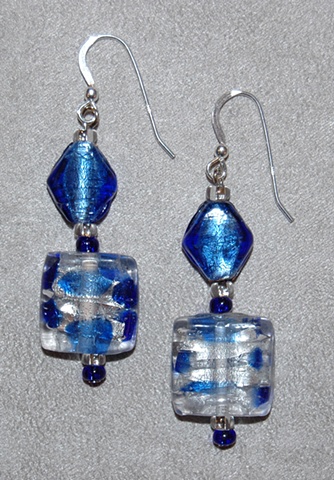 Earrings of Murano style square-shaped glass bead with silver foil and shades of cobalt and sapphire blue accented with diamond-shaped cobalt blue murano style glass 