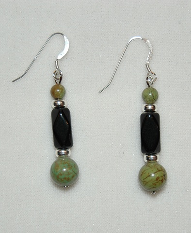 Earrings of round-shaped Chinese turquoise beads with faceted tube-shaped black glass bead accented with silver plated heishi spacers 