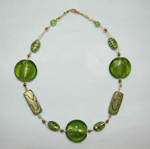 Triple strand interwove necklace comprised of incised 22k gold leaf over green glass beads  accented with large puff-coin-shaped murano style green glass beads 
