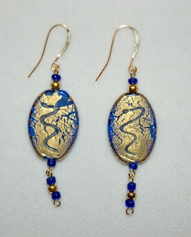 Earring so incised gold foil over cobalt blue glass bead, oval in shape, accented with cobalt blue glass seed beads and round gold-plated metal spacers  