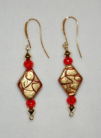 Earrings crafted from incised gold foil over red glass beads with red crystal accents