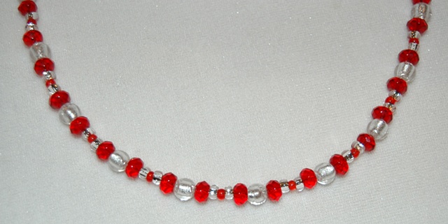 Necklace of Sparkling Silver colored Murano style Glass beads, round-shaped with ruby red faceted rondell-shaped crystal beads