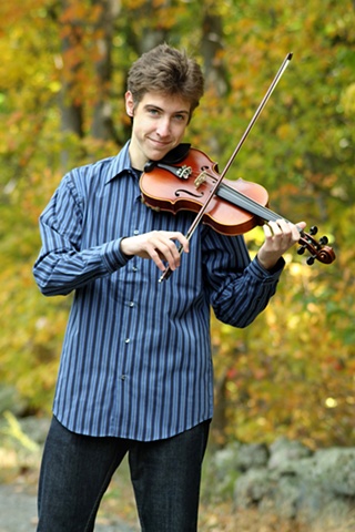 A portrait of high school senior Daniel playing violin. 