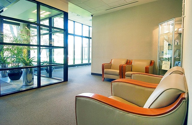 Interior lobby of office building with leather chairs and view to outside from floor to ceiling glass. 