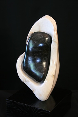 This is a modern contemporary stone sculpture of a seed pod that contains a very ripe seed by Denis A. Yanashot