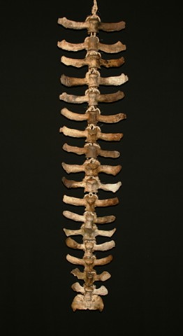 This is a modern contemporary mixed media sculpture of a large rhythmic vertebral column by Denis A. Yanashot