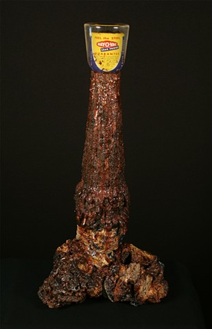 Leak Proof is a mixed media sculpture by Scranton, Pennsylvania sculptor Denis A. Yanashot. This sculpture is composed of defunct anthracite coal waste (burnt culm clumps), acrylic paint, epoxy resin, D size Flashlight battery, mica powders.. 