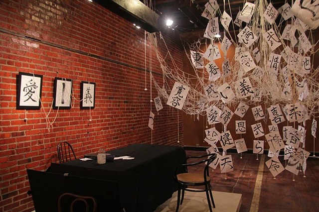 installation art with Japanese calligraphy and threads