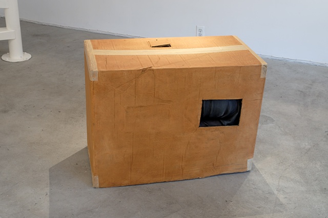 Figurative polychrome ultracal sculpture of adult man in cardboard box with cutouts