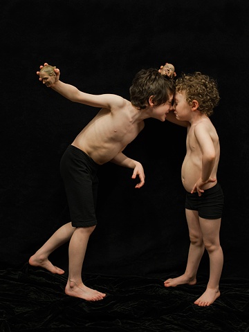 Digital C-prints of two boys, nose to nose,  holding tiny sculpted heads
