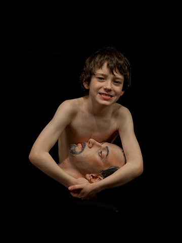 Digital C-prints of a boy on black background holding a sculpted man's head